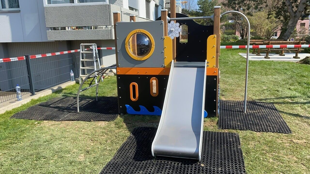 Rubber grass mats placed under slide