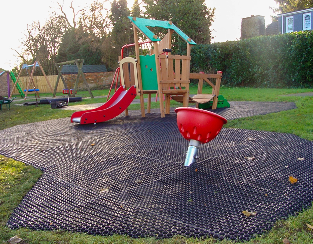 Rubber grass mats installed underneath a play tower